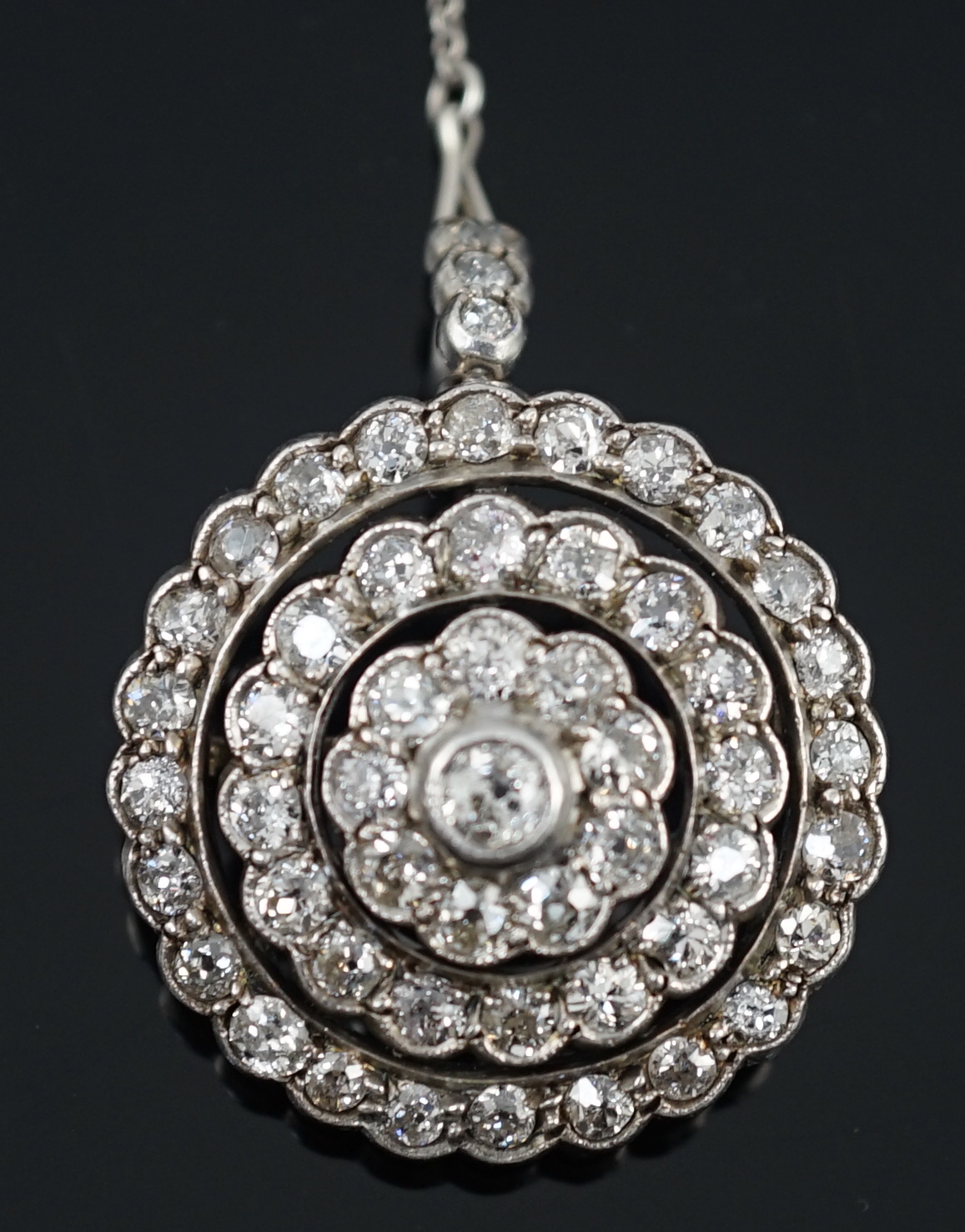 An early 20th century gold, platinum and millegrain set diamond cluster target brooch